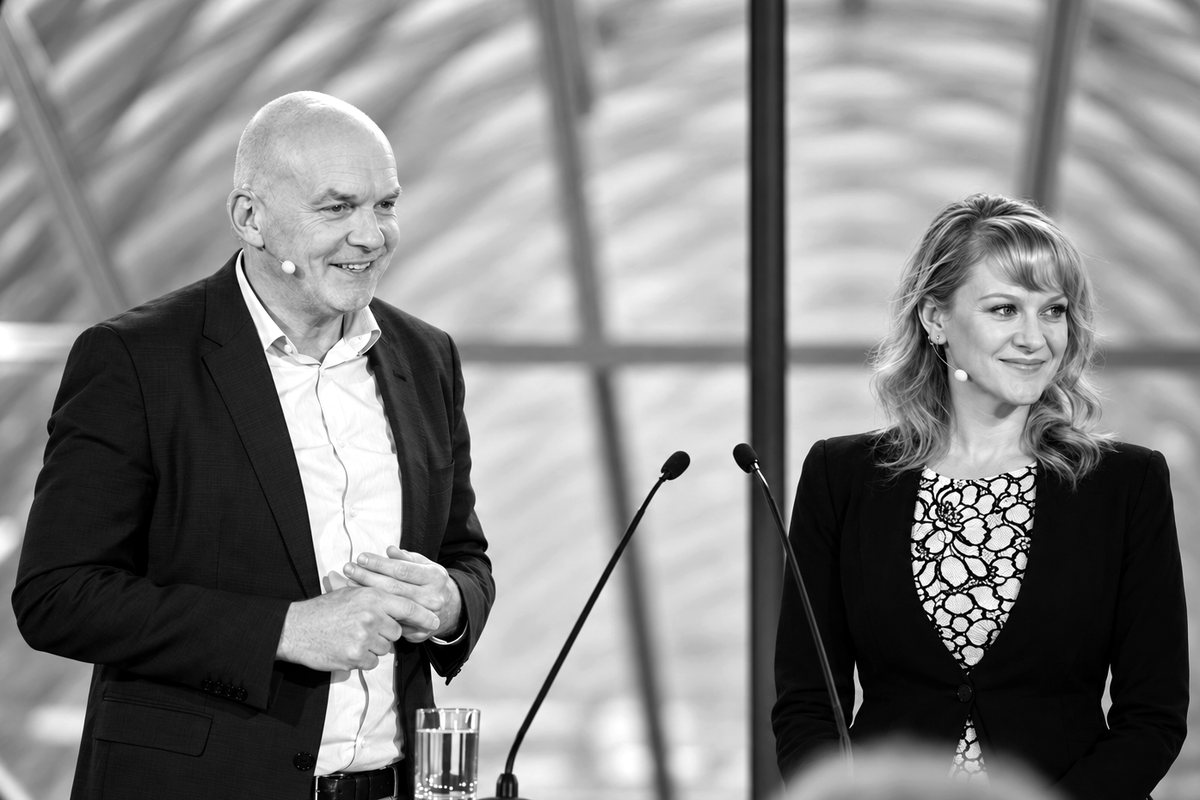 Bettina Kochheim und Prof. Dr. Dr. Michael von Bergwelt stehen beim Forum Immunonkologie auf der Bühne an zwei Mikrofonen.